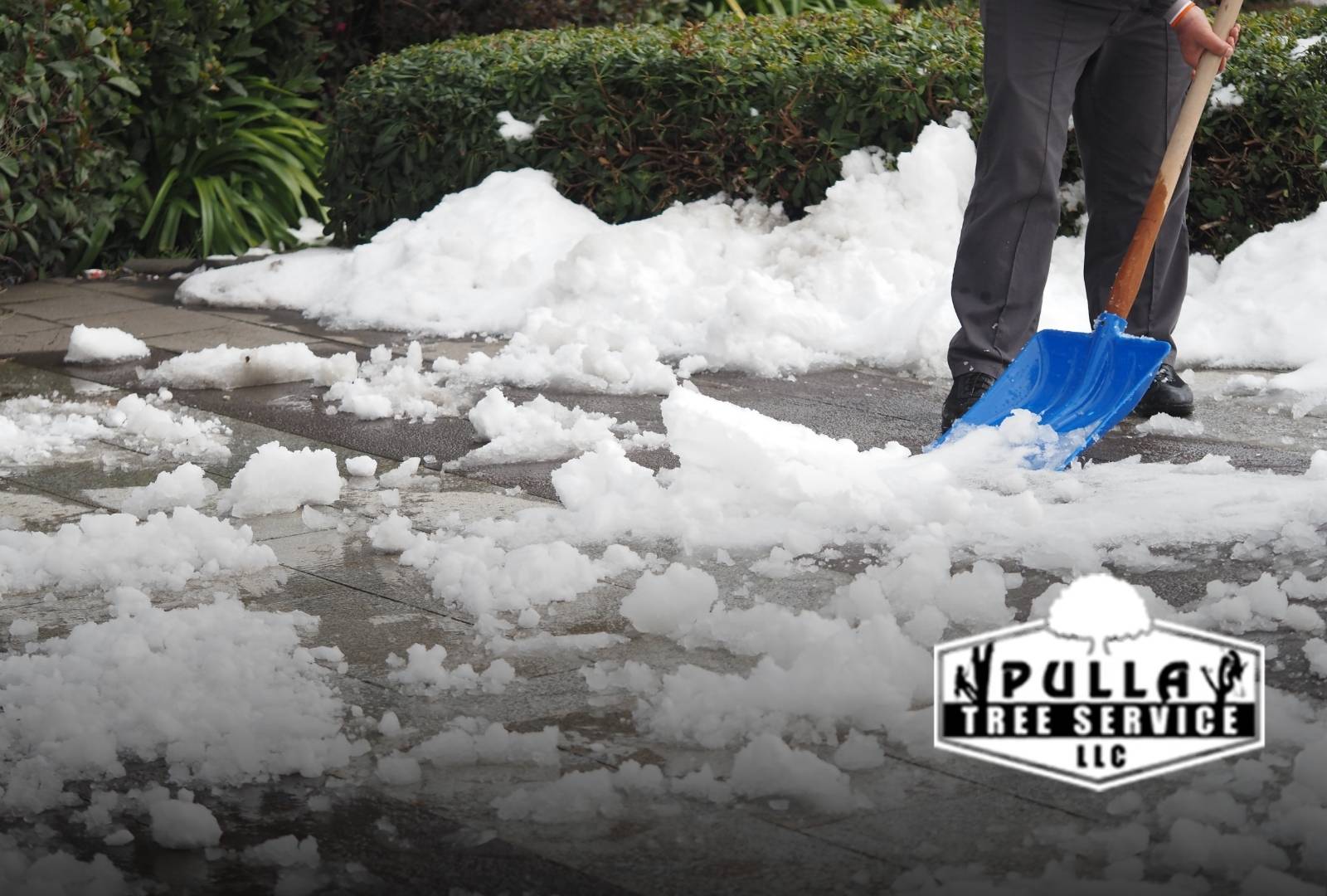 Homeowner performing storm clean-up after early snow and ice with safety gear